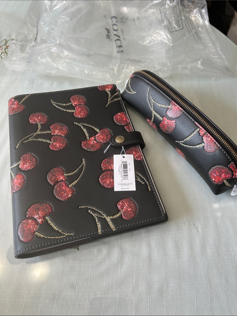 Coach Black Cherry-Print Leather notebook and pencil case.